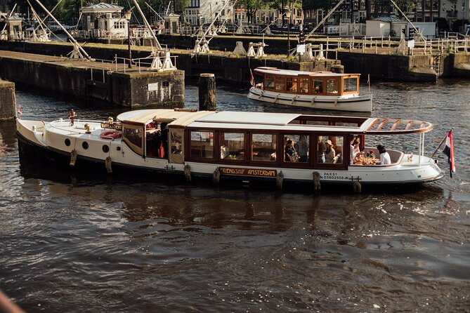Amsterdam: Luxury Saloon Boat Cruise with Cocktails & Waffle - Boarding at Oudezijds Voorburgwal, with the NH Krasnapolsky dock setup