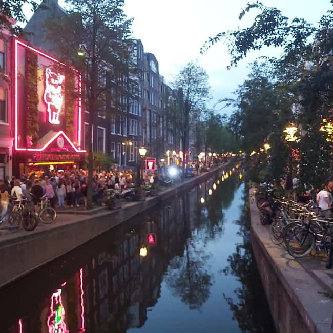 Amsterdam: Spanish Tour Unmasking the Redlight District - Getting oriented: Barbizon Palace Hotel and the St. Nicholas Basilica setup