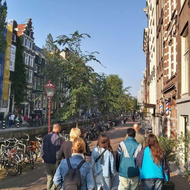 Amsterdam: Spanish Tour Unmasking the Redlight District - Warmoesstraat, a temple photo stop, and the surprise pauses